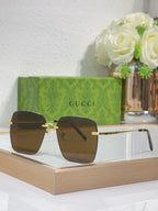Gucci sunglasses with gold-tone frame and dark square lenses on display, front view.