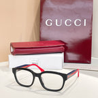 Gucci eyeglasses with black frames, red temple accents, and green highlights; clear lenses.