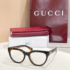 Black eyeglasses with clear lenses and tortoise-style temples, Gucci hardware