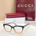 Dark blue eyeglasses with clear lenses and tan temples, Gucci hardware