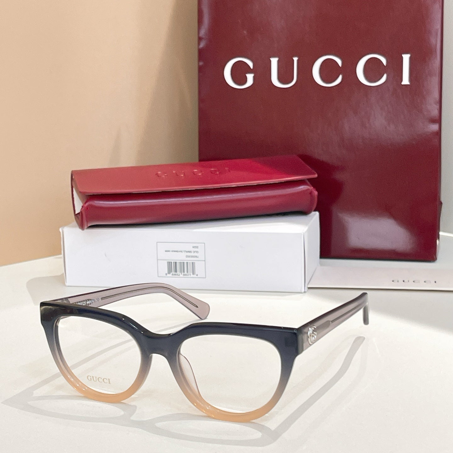 Dark blue eyeglasses with clear lenses and tan temples, Gucci hardware
