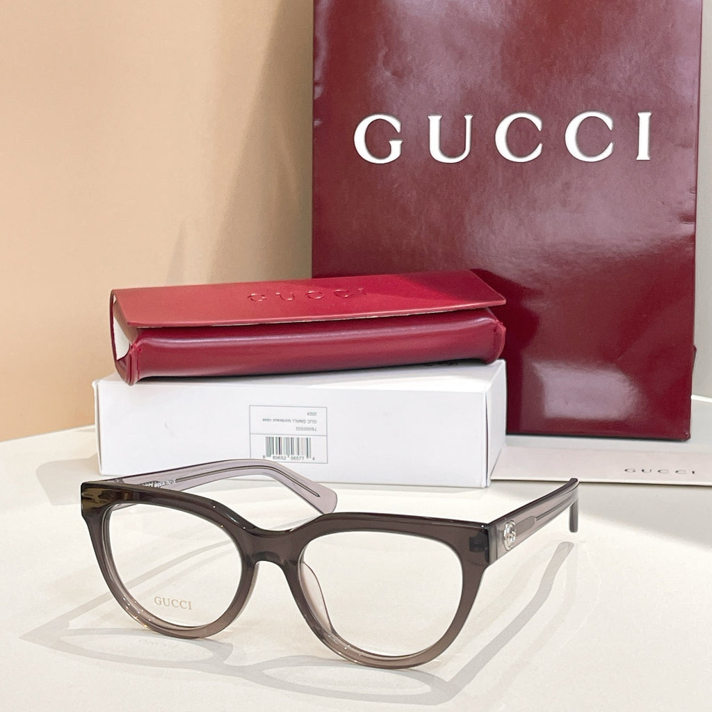 Dark eyeglasses with clear lenses and light tan temples, Gucci hardware
