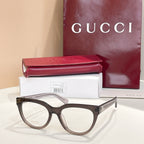Dark eyeglasses with clear lenses and light tan temples, Gucci hardware
