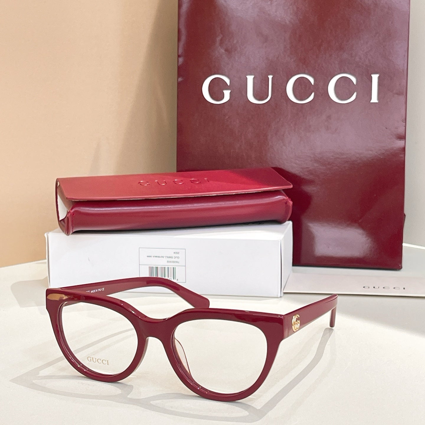 Burgundy eyeglasses with clear lenses and gold-tone Gucci hardware