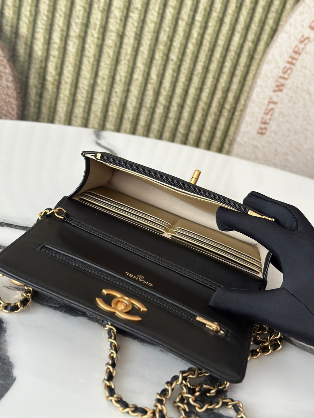 Open Chanel black bag showing interior compartments and gold-tone hardware