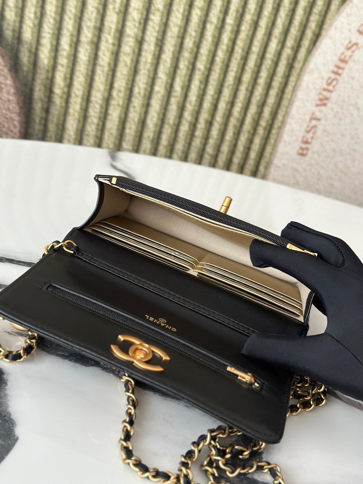 Open Chanel black bag showing interior compartments and gold-tone hardware