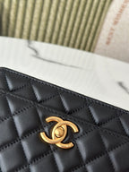 Close-up of black quilted Chanel bag front with gold-tone CC logo