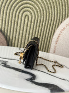 Chanel black shoulder bag with gold-tone hardware and chain strap, side view