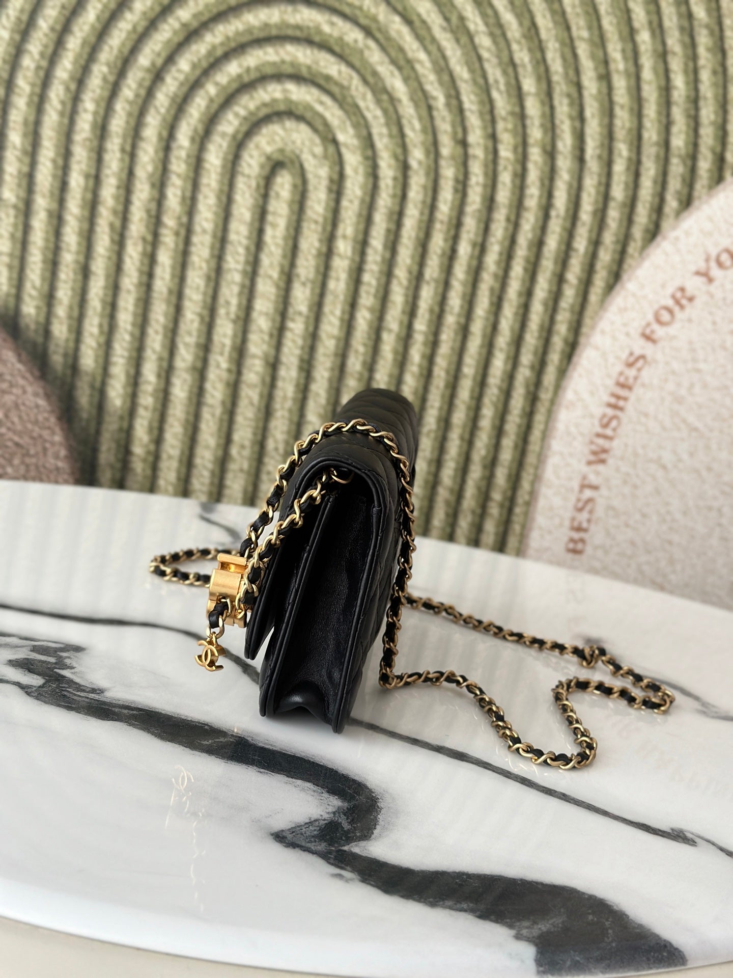 Chanel black shoulder bag with gold-tone hardware and chain strap, side view