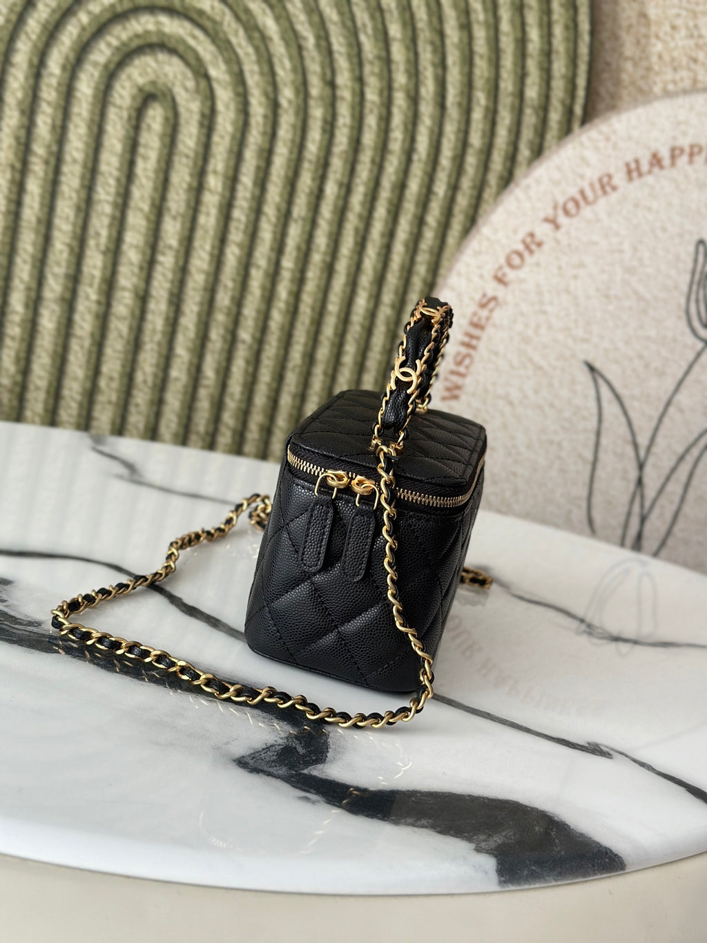 Chanel quilted mini bag side view with gold chain strap and zip top, black