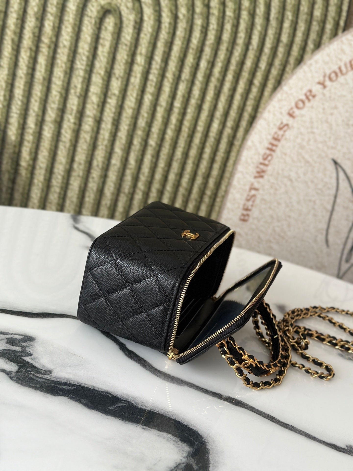 Chanel quilted mini bag open angle view with gold zipper and chain, black