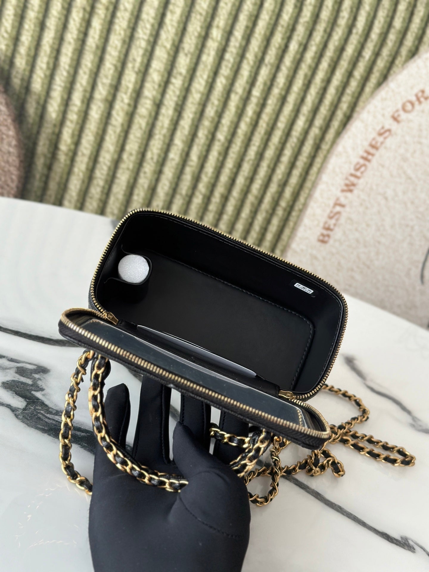 Chanel mini bag open top with interior lining visible, black leather and gold trim
