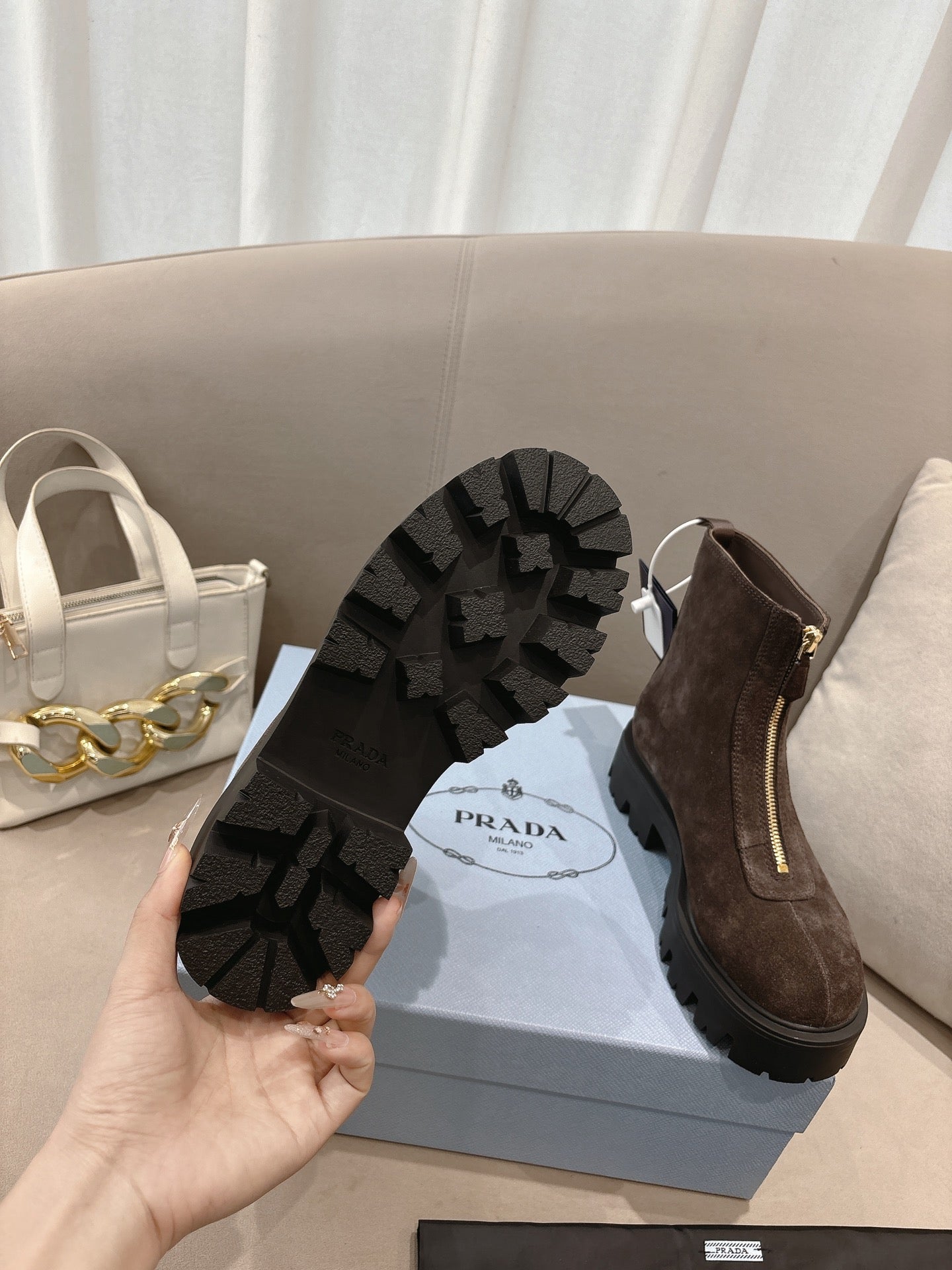 Prada ladies ankle boots, dark brown suede; view of black lug outsole tread.