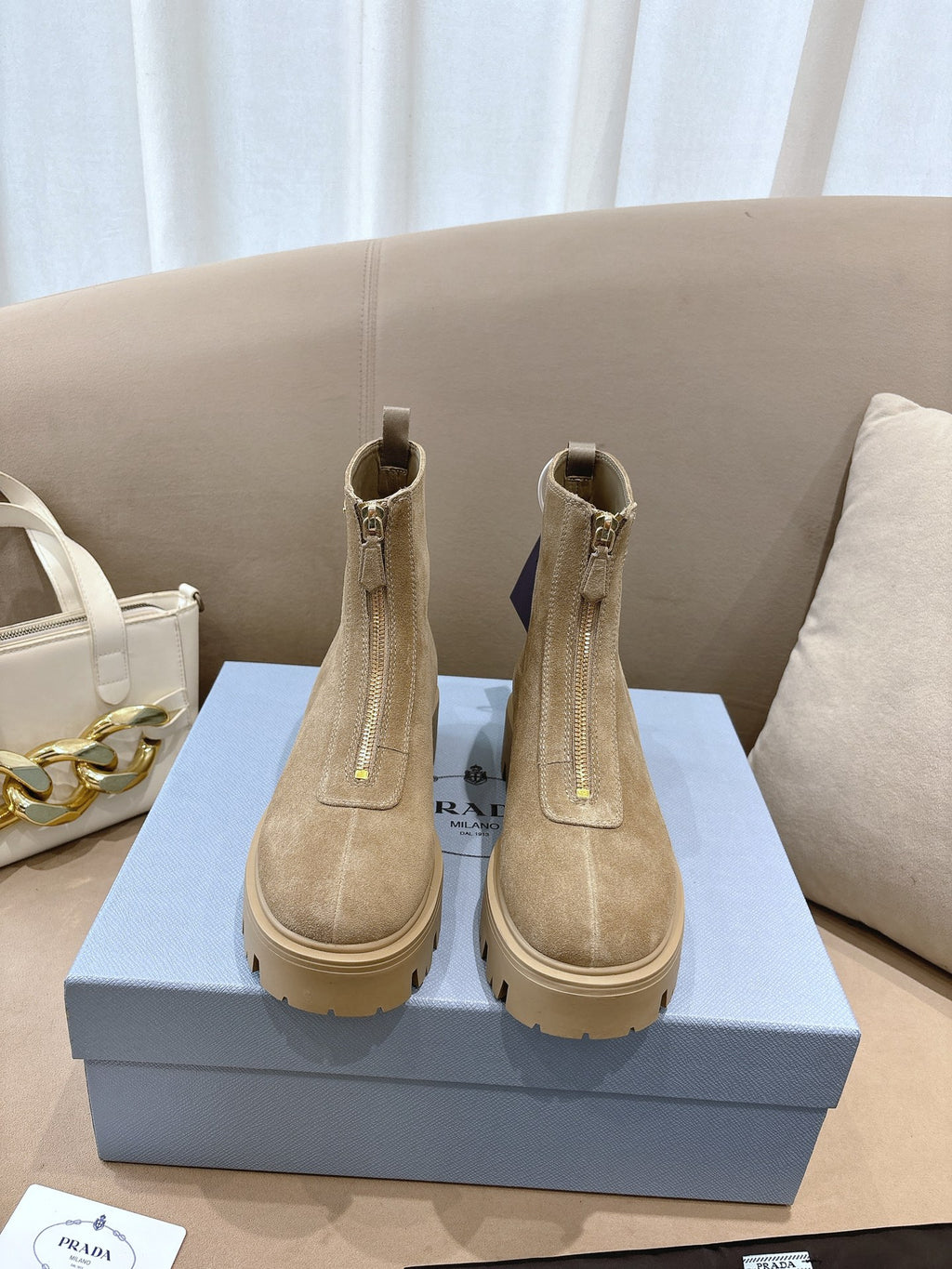 Beige suede Chelsea ankle boots with lug soles, side elastic, and heel pull tabs
