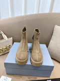 Beige suede Chelsea ankle boots with lug soles, side elastic, and heel pull tabs