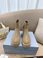 Beige suede Chelsea ankle boots with lug soles, side elastic, and heel pull tabs