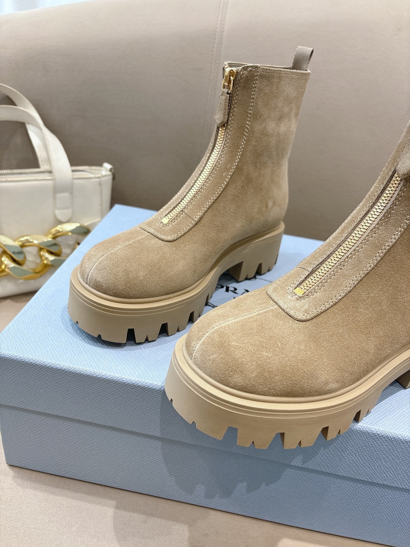 Beige suede Chelsea ankle boots with lug tread sole, side elastic gore, and pull tabs