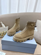 Beige suede Chelsea boots with triangular logo patch and chunky lug sole