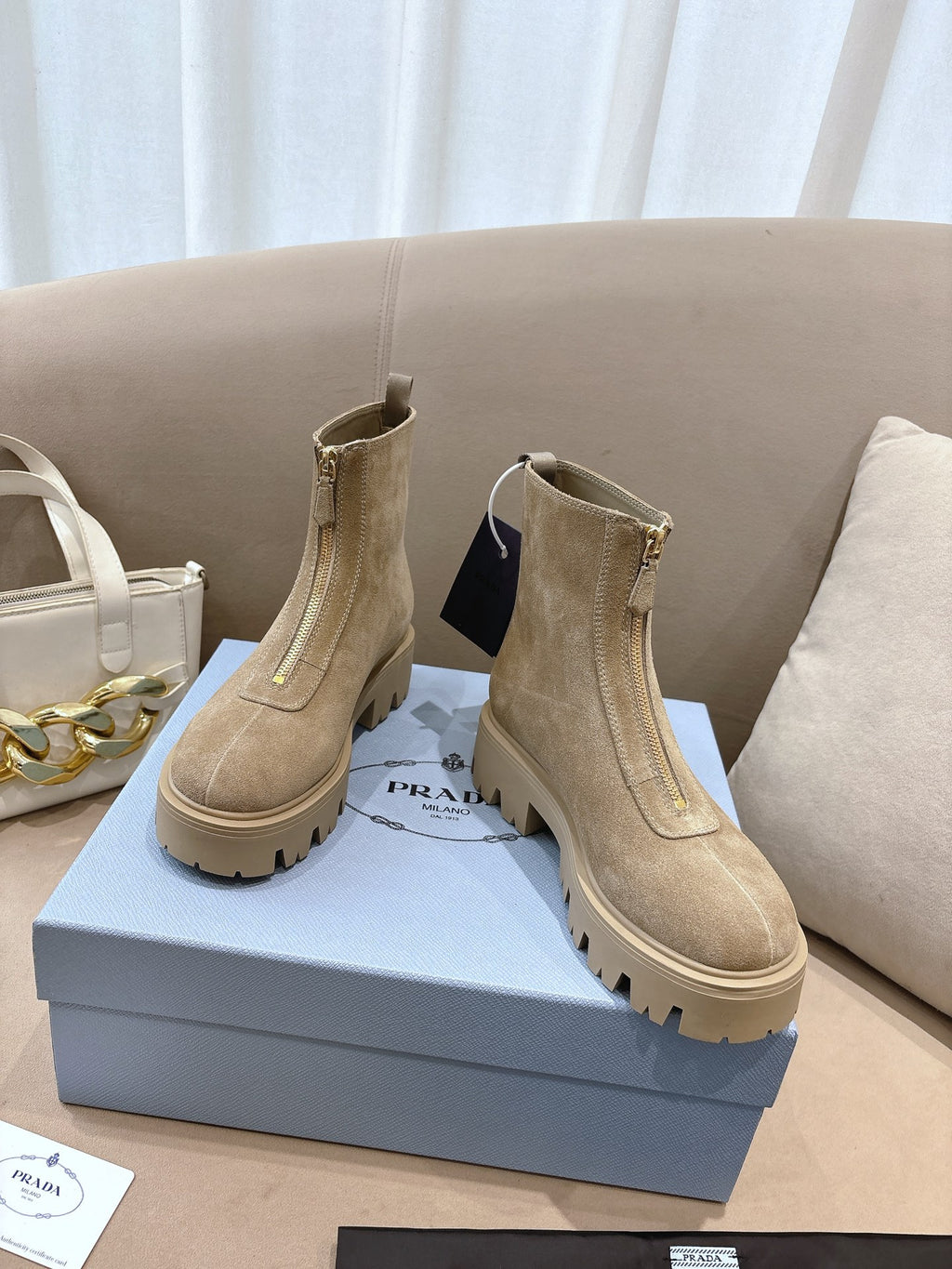 Beige suede Chelsea ankle boots with lug tread sole, side elastic gore, and pull tabs