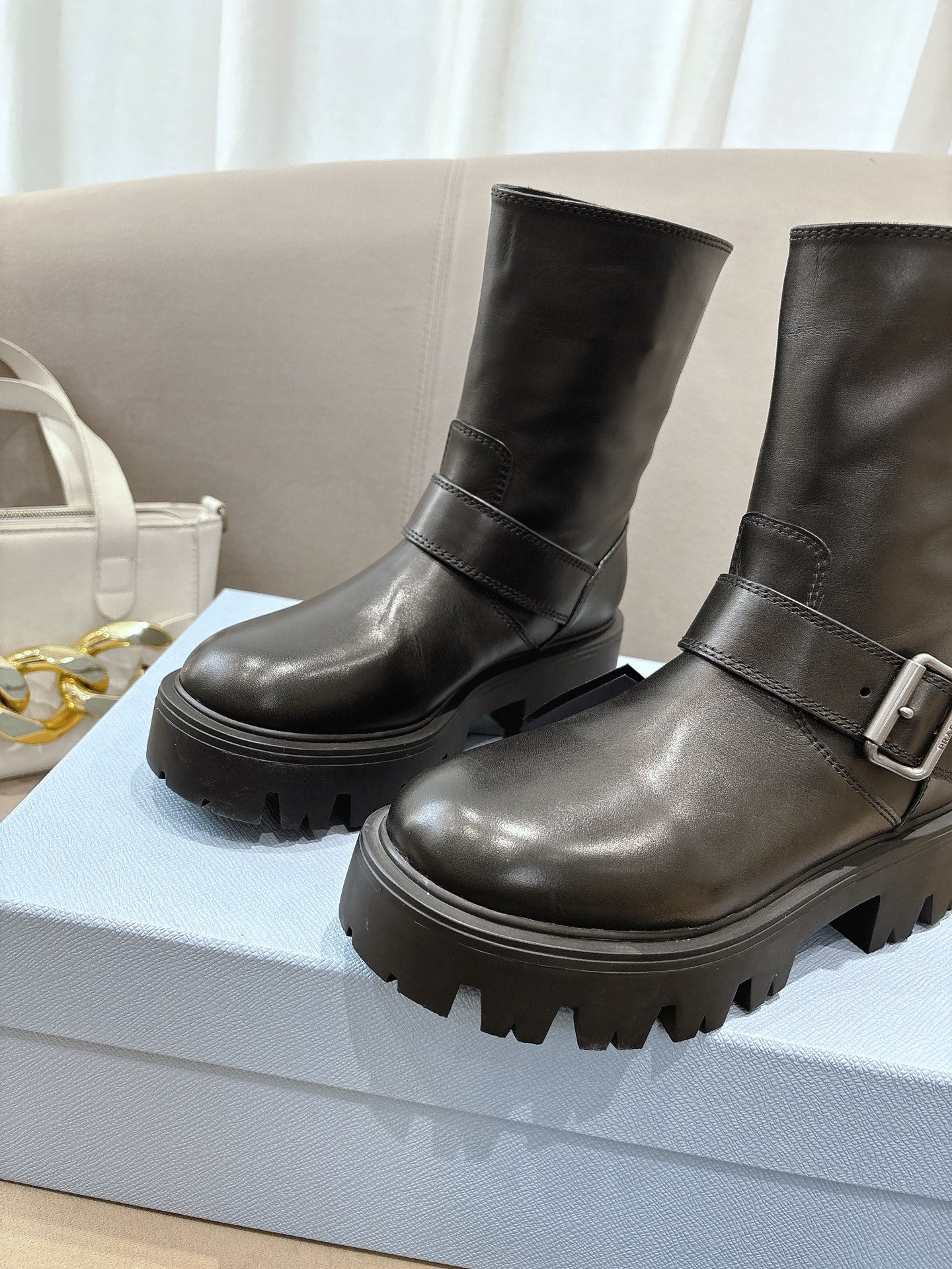 Prada ladies black leather mid-calf boots with wraparound strap and lug sole