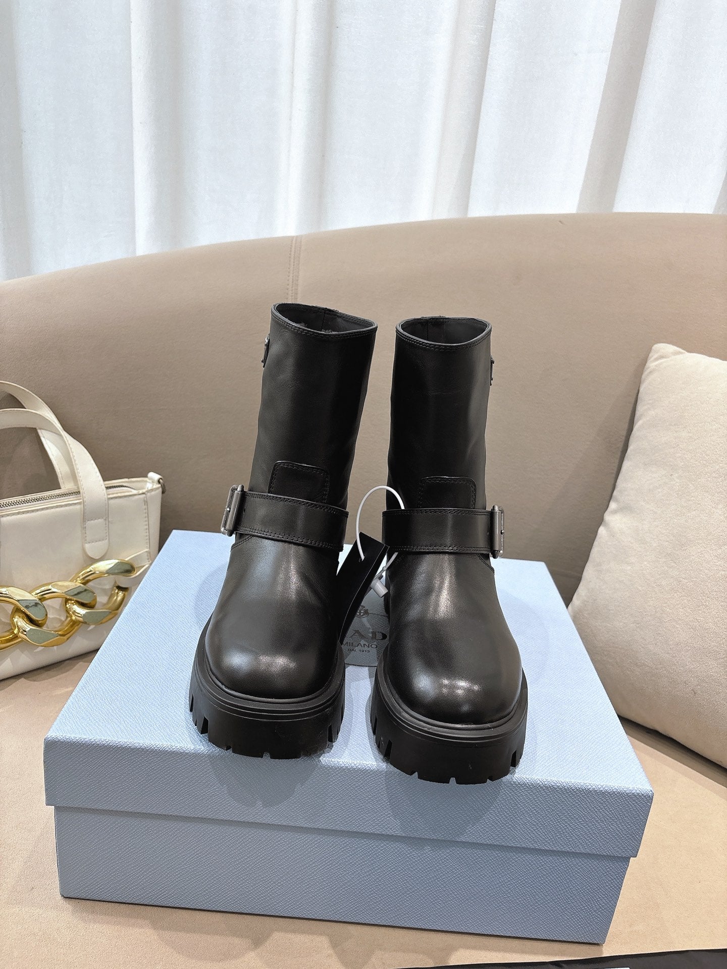 Prada ladies black leather mid-calf boots with buckle straps and lug soles