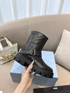 Prada ladies black leather mid-calf boots with triangular logo, buckle strap, lug sole