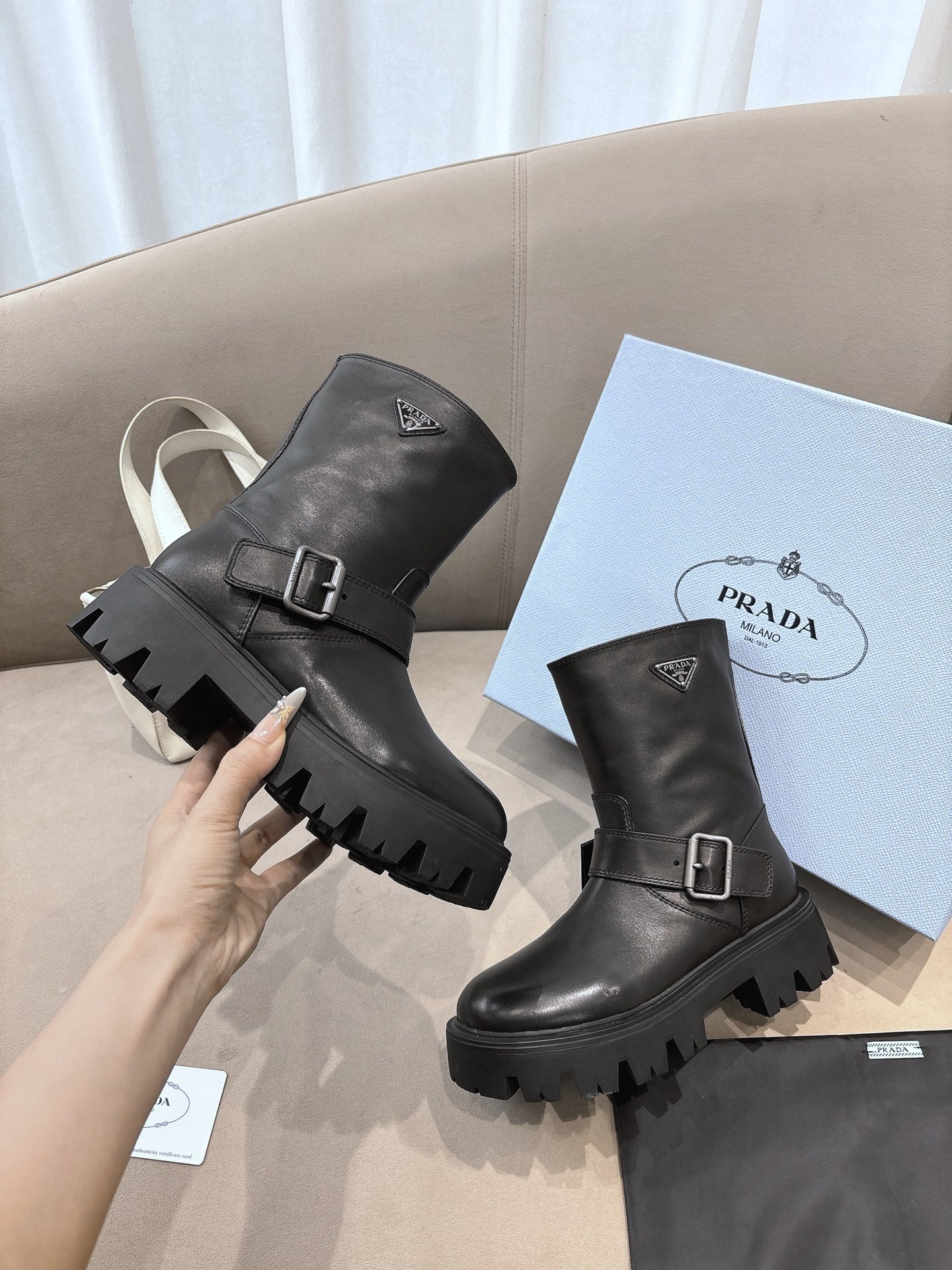 Prada ladies black leather mid-calf boots with buckle strap and lug sole