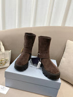 Pair of brown suede ankle boots with side strap buckle and lug sole
