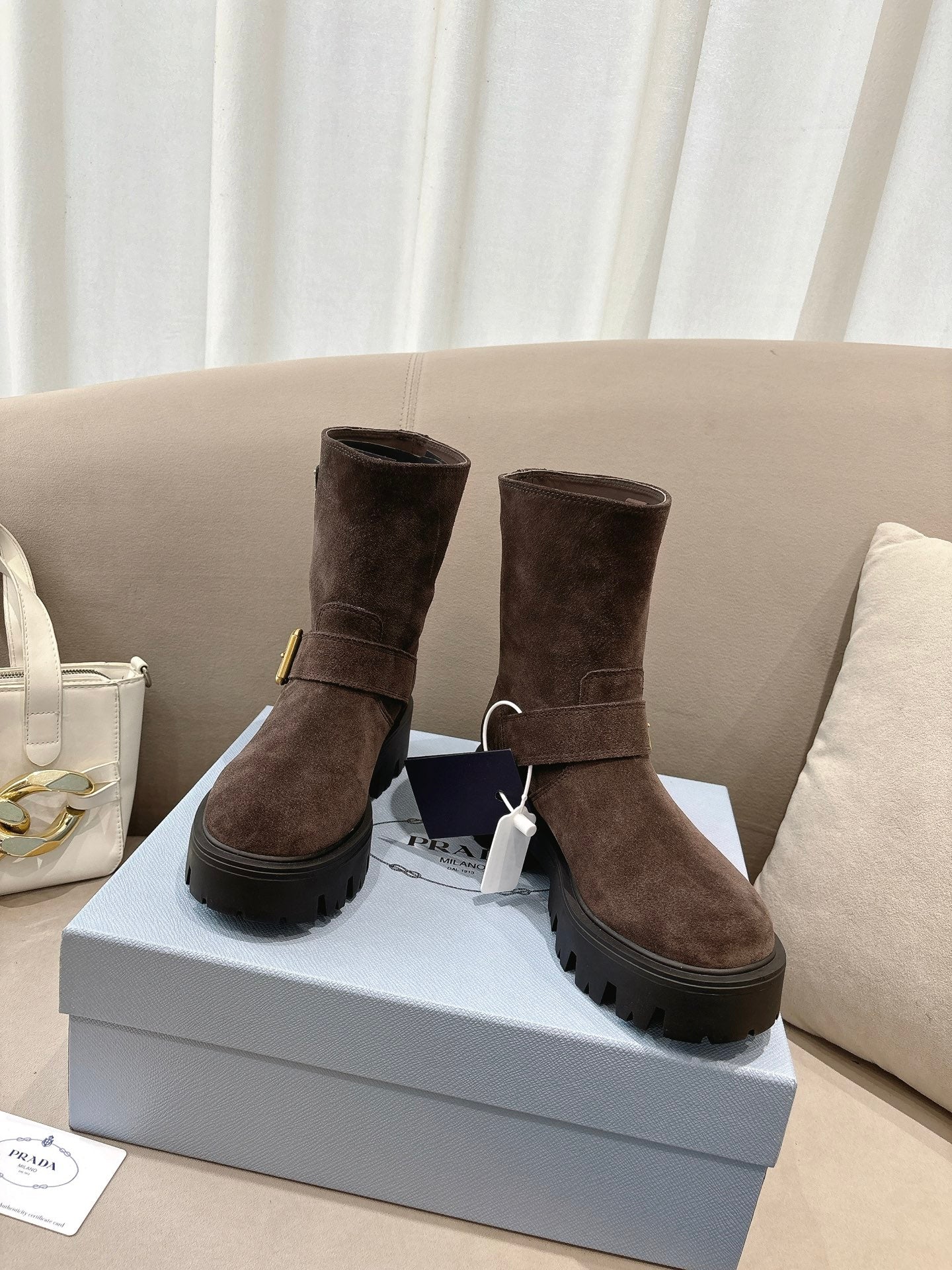 Pair of brown suede ankle boots with side strap buckle and lug sole