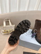 Brown suede ankle boots with black lug outsole tread visible