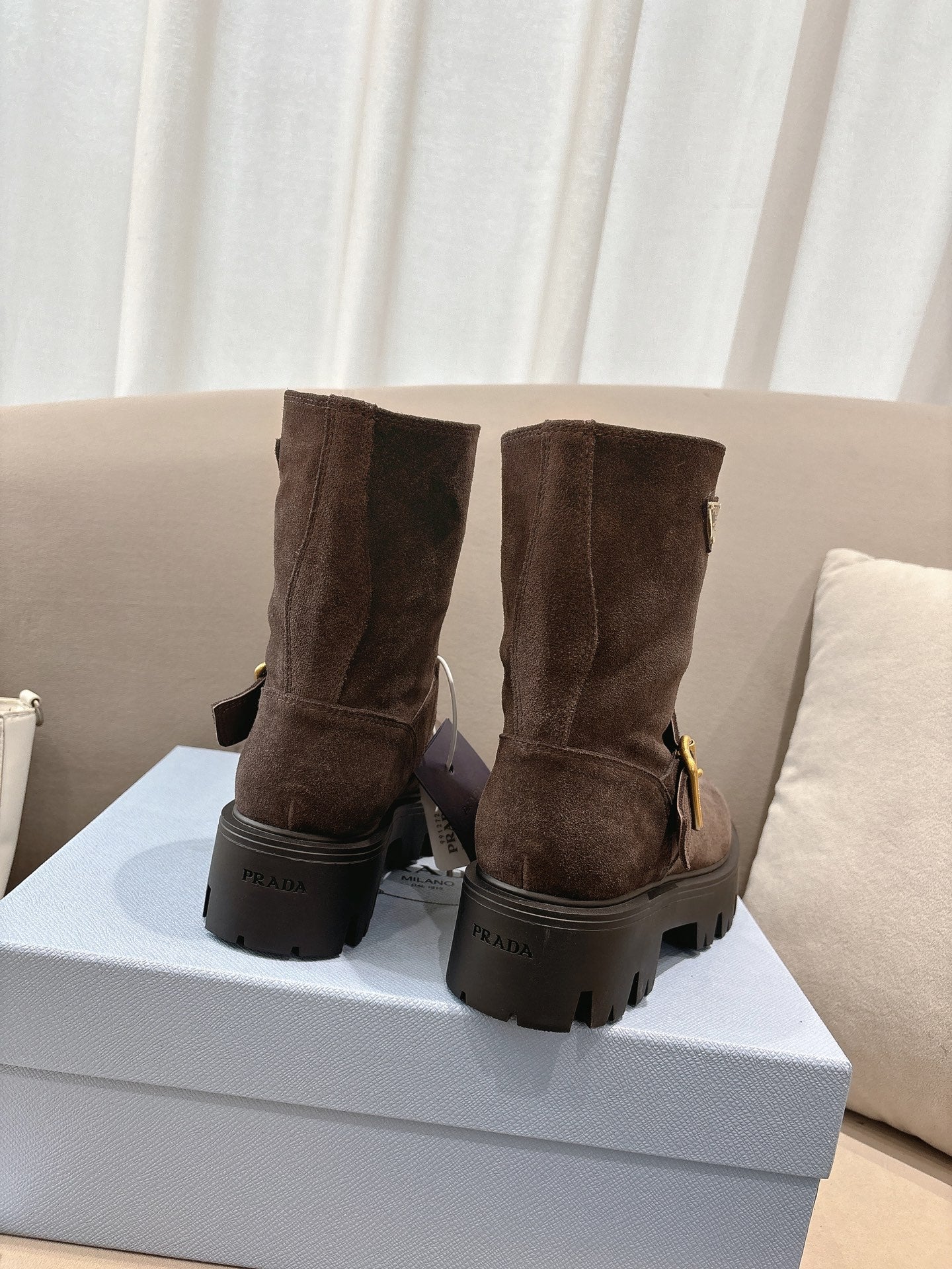 Brown suede ankle boots with pull tabs and thick lug soles, heel view
