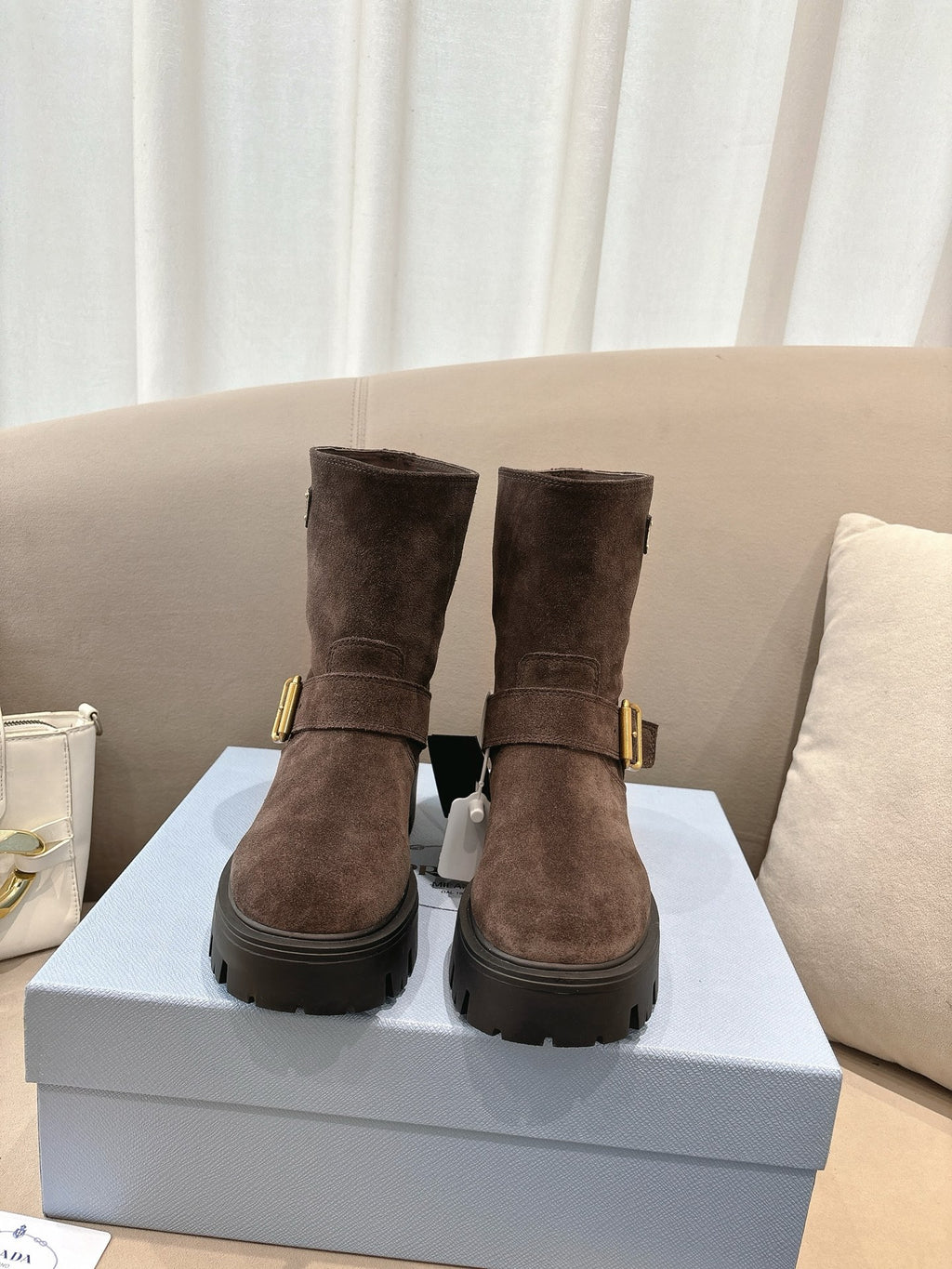 Brown suede ankle boots with gold buckle and chunky rubber sole