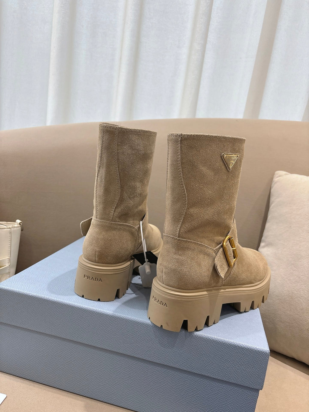 Prada women's suede ankle boots, beige, two-pair view with buckle accents and lug soles.