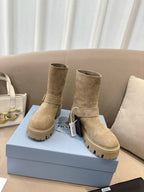 Prada women's suede ankle boots, beige, low shaft with buckle strap detail and lug soles.