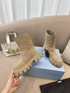 Prada women's suede ankle boots, beige, shown side view with buckle strap and lug sole.