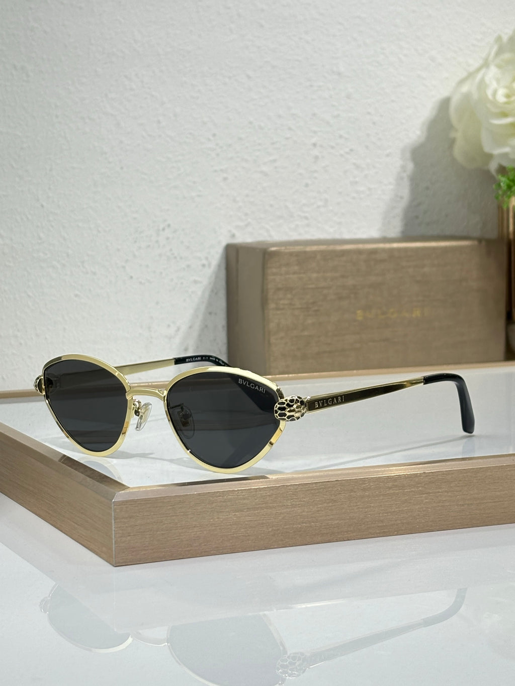 Bvlgari glasses with gold-tone metal frame and dark lenses, cat-eye shape