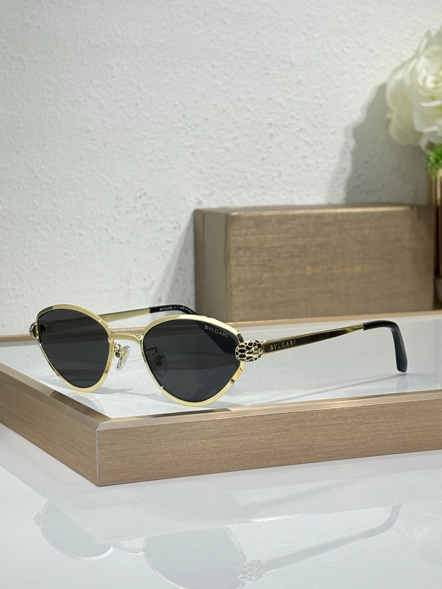 Bvlgari glasses with gold-tone metal frame and dark lenses, cat-eye shape