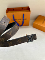 Monogram belt with gold-tone LV buckle, dark brown canvas strap and black leather lining.