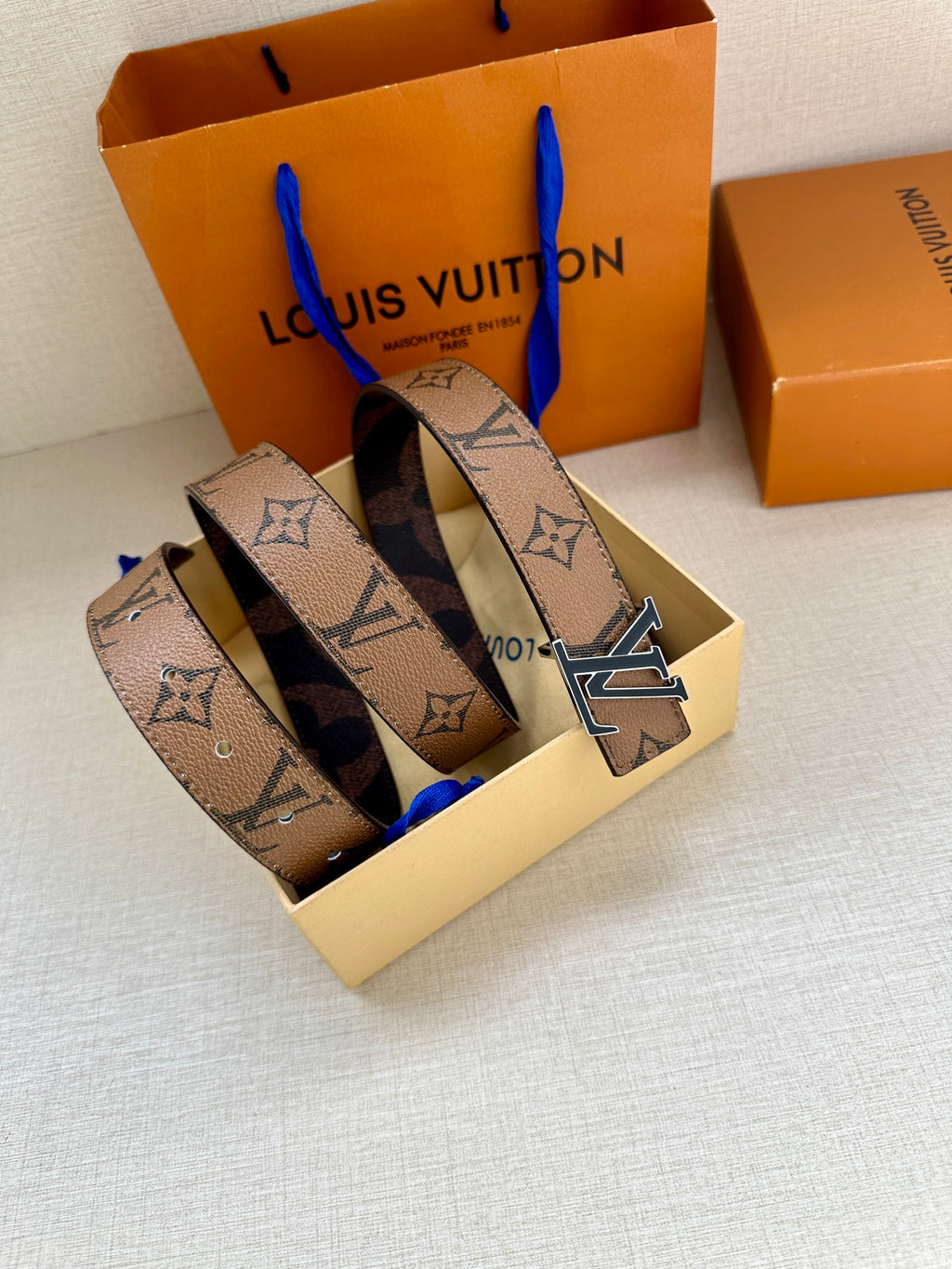 Louis Vuitton monogram belt set with gold-tone LV buckle and dark patterned straps