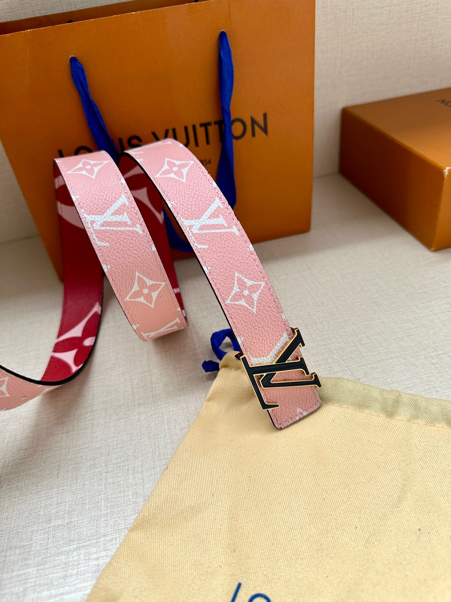 Pink monogram belt with red trim and silver LV buckle detail