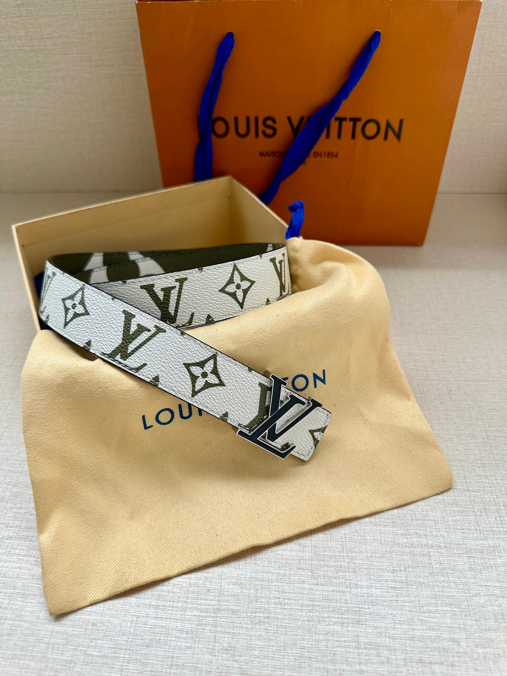Louis Vuitton belt with white monogram strap and dark green trim, silver LV buckle