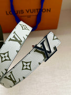 Louis Vuitton belt close-up: white monogram strap with silver LV buckle on dark green edge