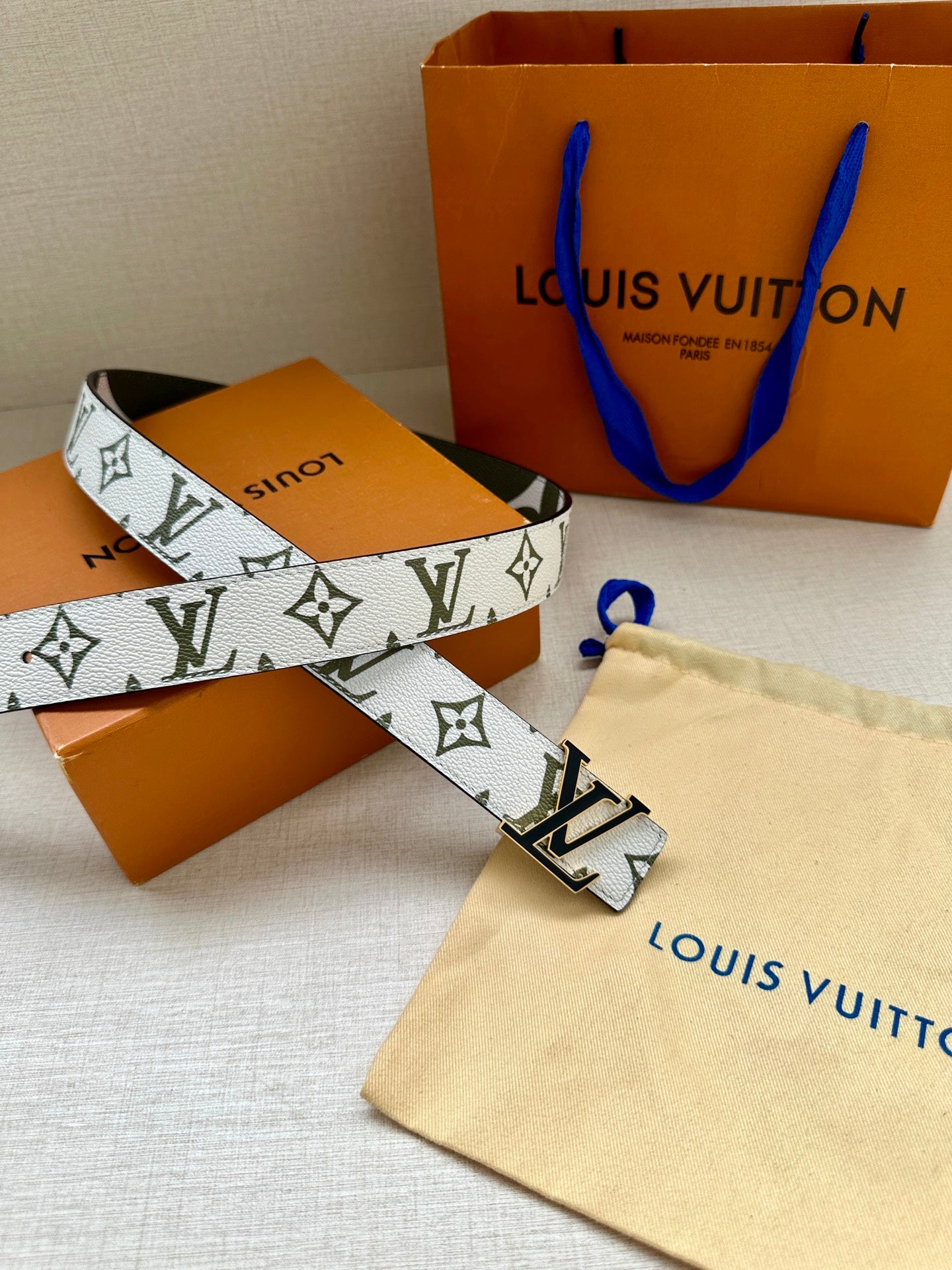 Louis Vuitton belt with white monogram strap, dark green trim, silver LV buckle
