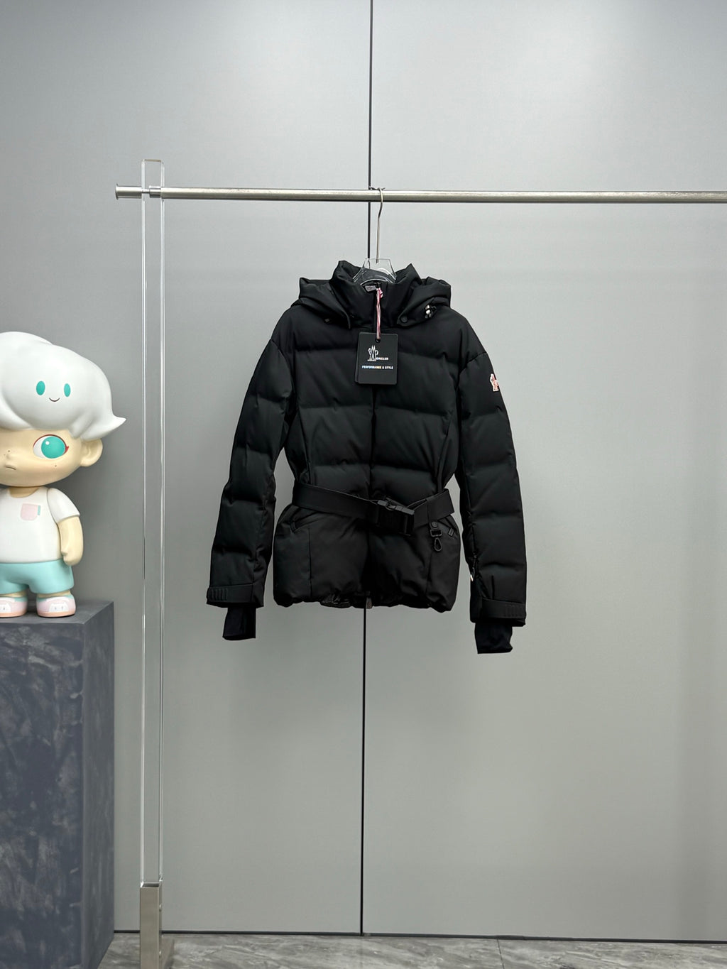 Black hooded long puffer jacket with front zipper and waist belt