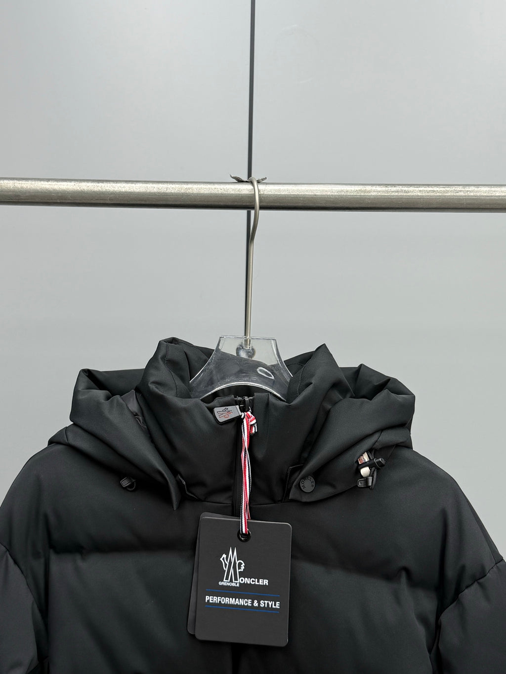 Black hooded puffer jacket chest area with brand logo label