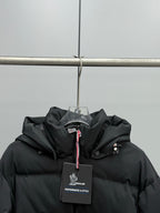 Black hooded puffer jacket chest area with brand logo label