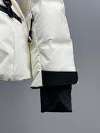 White puffer jacket with hood drawstring, black cuff detail, and hanging strap