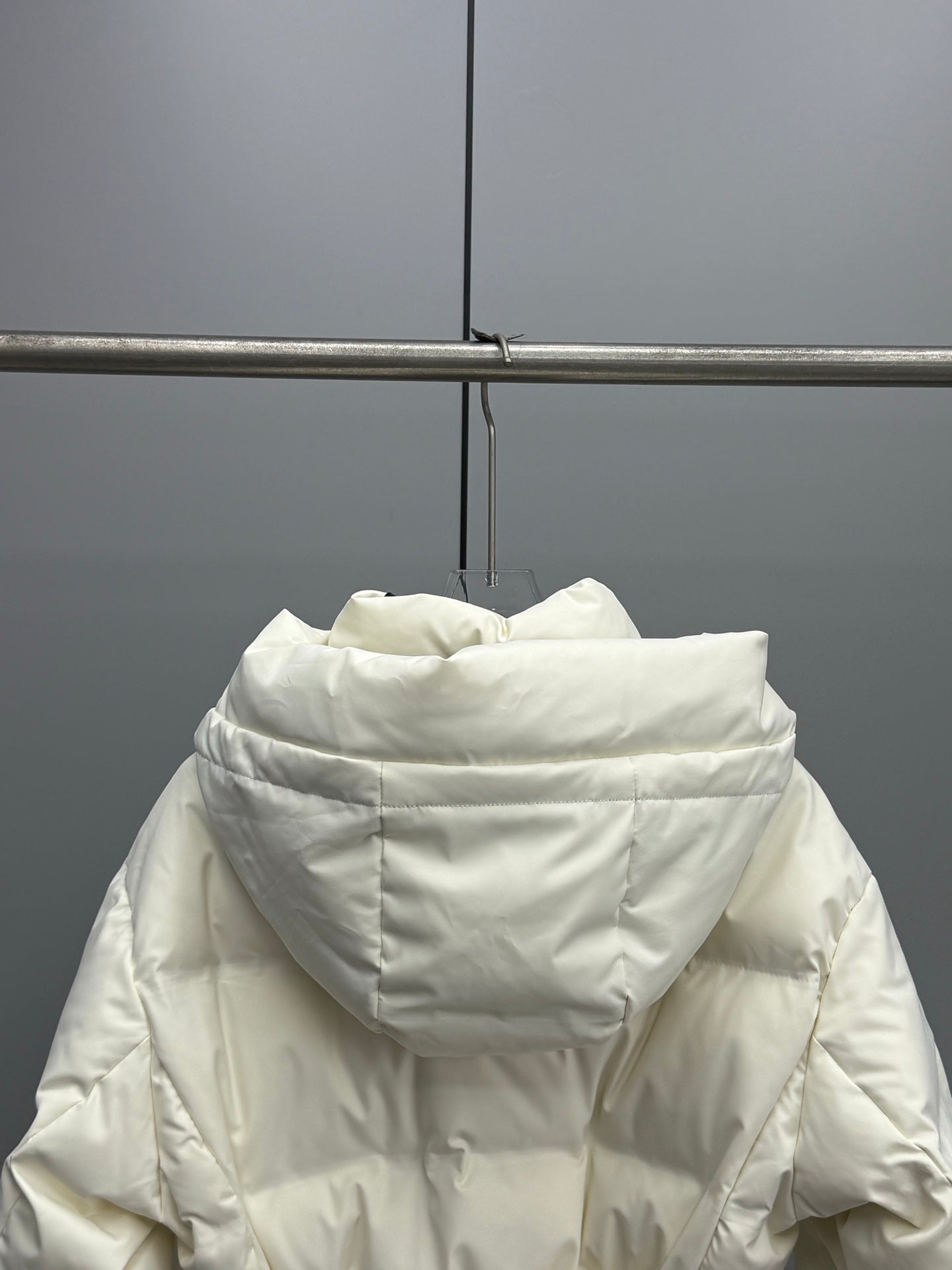White long puffer jacket with hood, front zipper, and padded collar