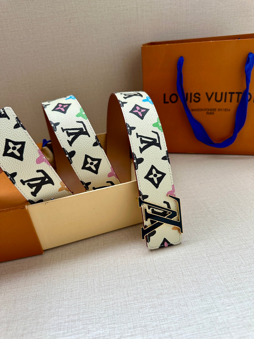 Leather LV monogram belt with gold buckle, two folded straps shown