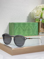 Gucci round sunglasses with dark lenses and black frame with silver-toned temples